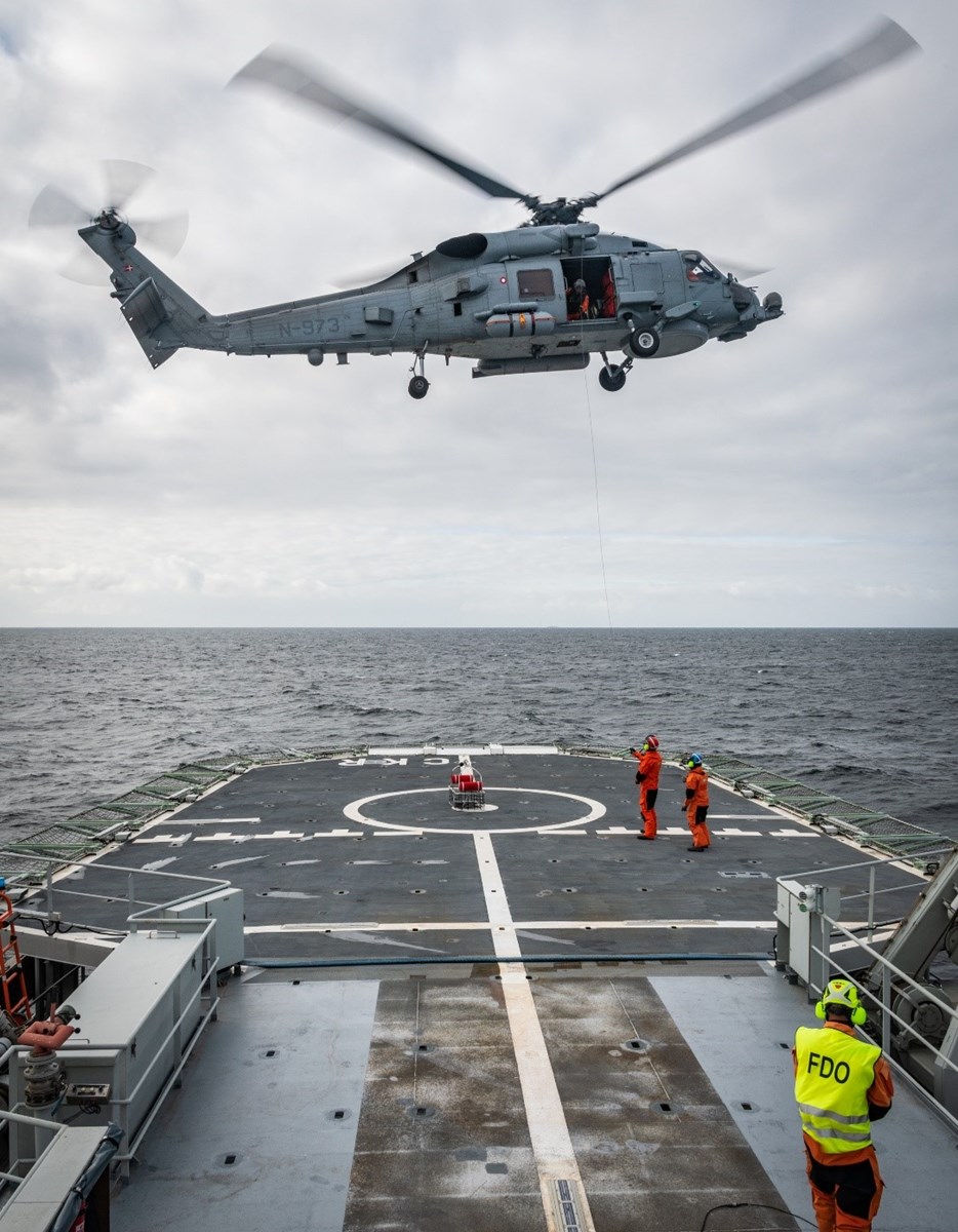 Helikopter landar på helikopterplatta ombord fartyg.