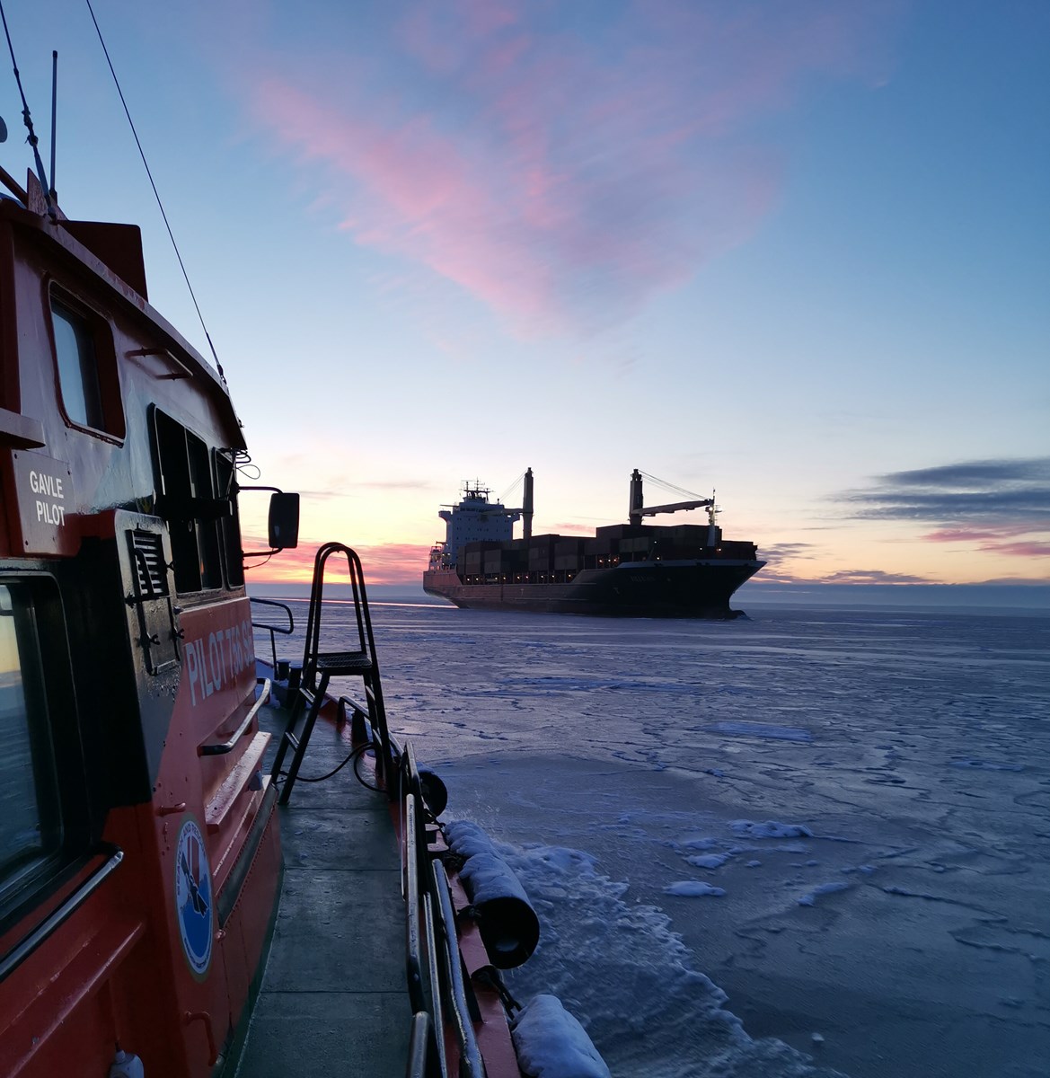 Lotsbåt med lastfartyg i bakgrunden.