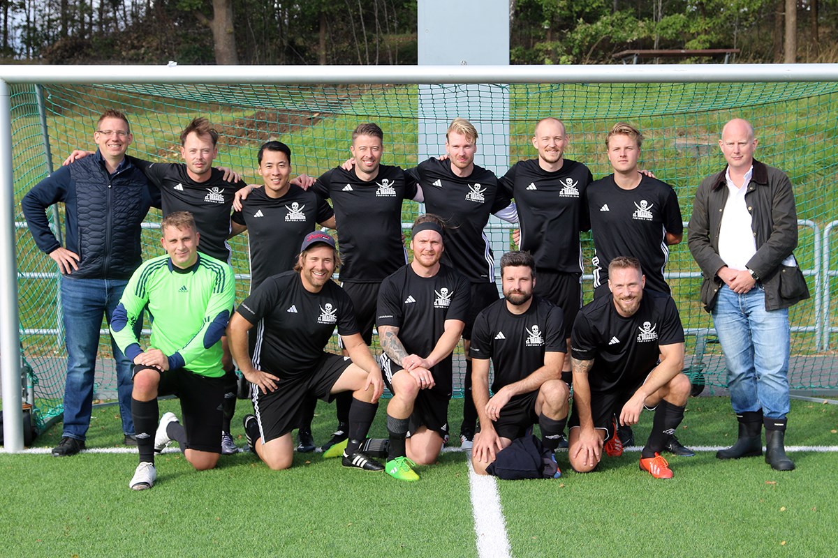 Ett fotbollslag står uppställda för en gruppbild, i ett fotbollsmål