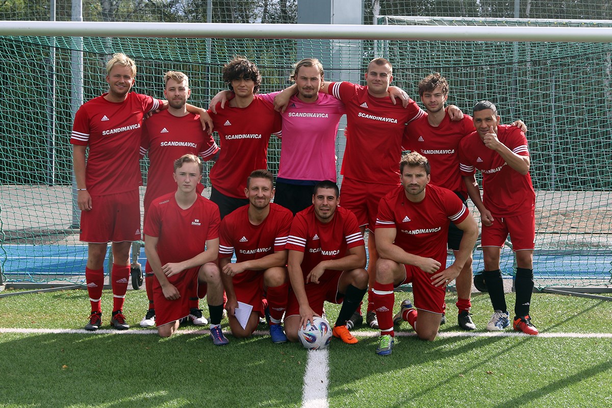Gruppbild på ett rödklätt lag i ett fotbollsmål