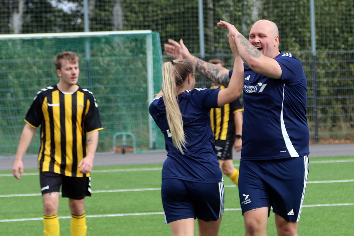 Två spelare ger varandra en dubbel high-five, medan motspelarna ser något molokna ut