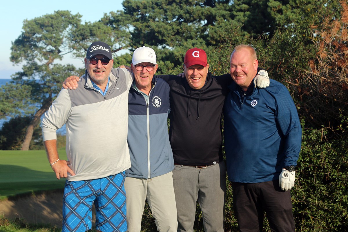 Fyra golfspelare poserar för kameran