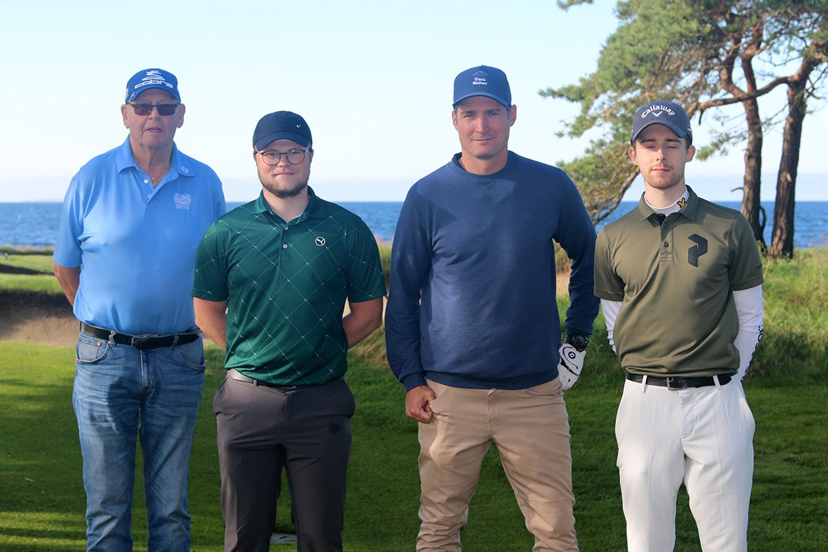 Fyra spelare kisar in i kameran, med havet bakom sig