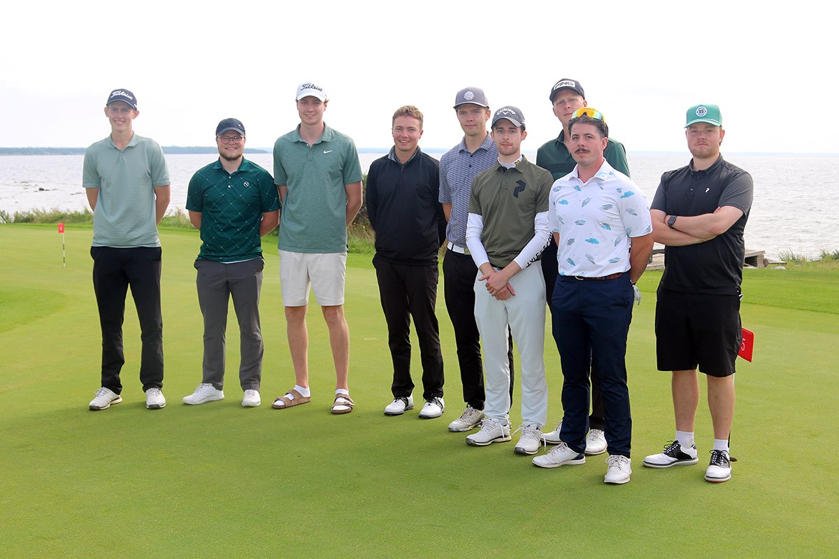 En grupp med nio sjöbefälsstudenter uppställda med havet i bakgrunden